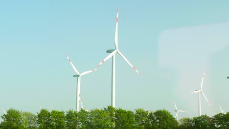 passing by wind farms in the german countryside in slow motion