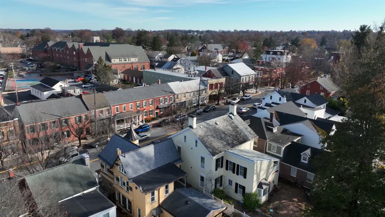 Luftoptagelse af den historiske by Lititz, Pennsylvania om vinteren, der viser gader i en lille by, murstensbygninger og beboelseshuse med let sne under en klar himmel. Bredt billede.