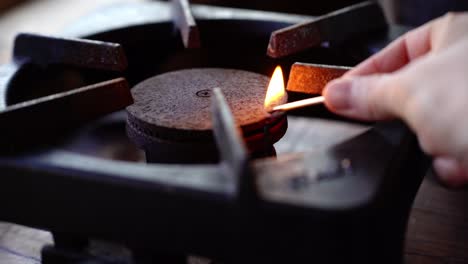 lighting an old gas stove with a match