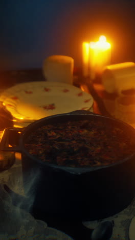 candlelit dinner with steaming pot of stew