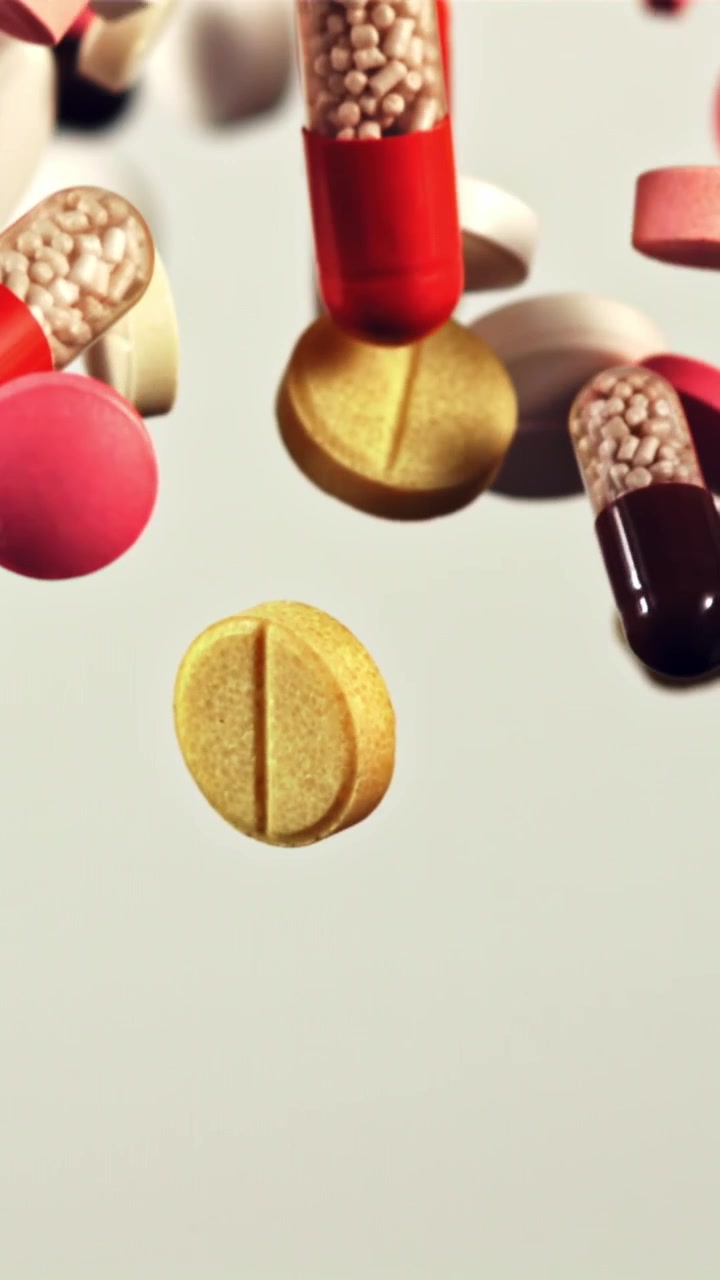 Pillole e capsule colorate che cadono al rallentatore