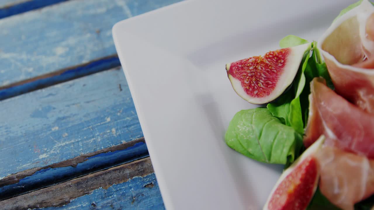 Camera zooming out revealing plate with figs, prosciutto while map overlay growing HUD showing data