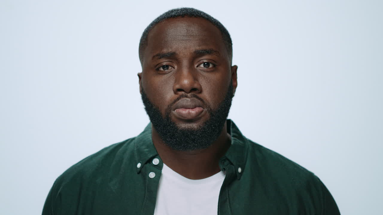 Portrait of serious african handsome raising head in grey background.