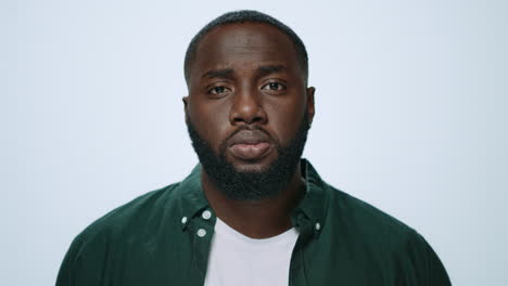 retrato de un serio y guapo africano levantando la cabeza en un fondo gris.