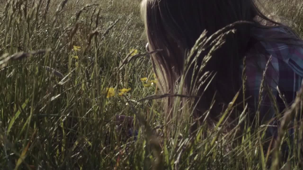 Donna seduta in un prato con fiori di ranuncolo