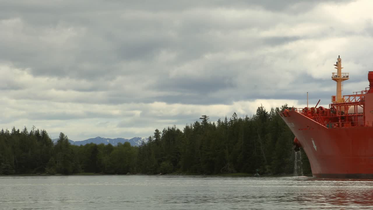 Serene view of Loch Long near Arrochar, Scotland, showing calm waters, forested Highlands, and the bow of a docked vessel beneath a cloudy sky