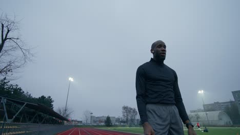 man looking at his watch during track and field event