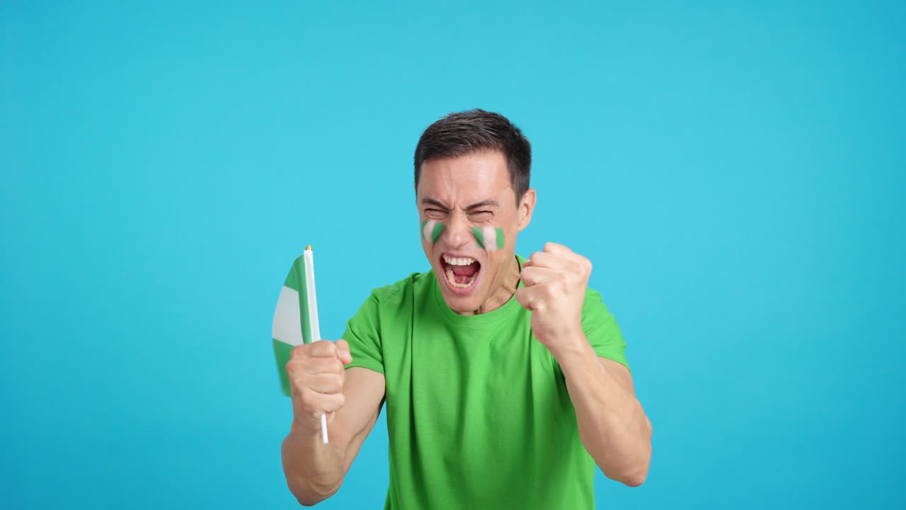 Man cheering for Nigeria screaming and waving a national flag