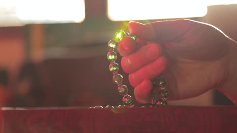 slow motion footage of a person praying and making dhikr on his prayer beads