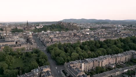Aerial track right to left of Edinburgh Castle surrounded by city centre and Edinburgh New Town with classic row houses, Scotland, UK