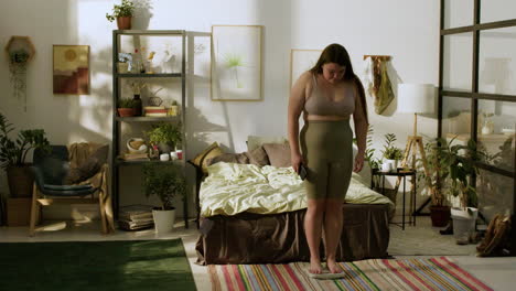 Young-woman-with-smartphone-on-her-bedroom