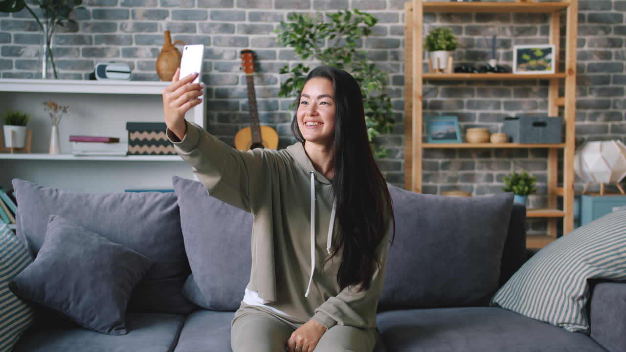 Woman taking a selfie on a couch