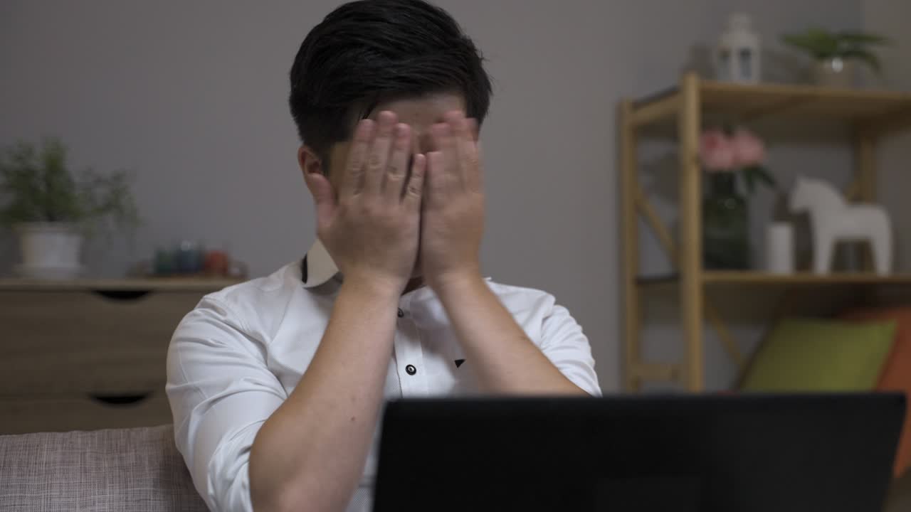 과장된 아시아 사업가, 잠들어서 충격에 빠진 표정으로 깨어나고, 집에서 늦게 일하면서 얼굴을 고 컴퓨터를 쳐다보고 있습니다.