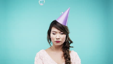 disappointed woman wearing a party hat with bubbles