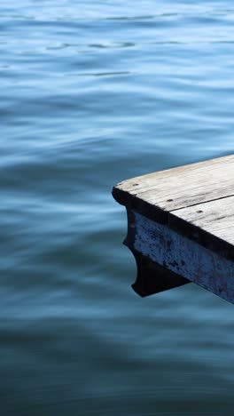 wooden dock gently sways above tranquil blue water