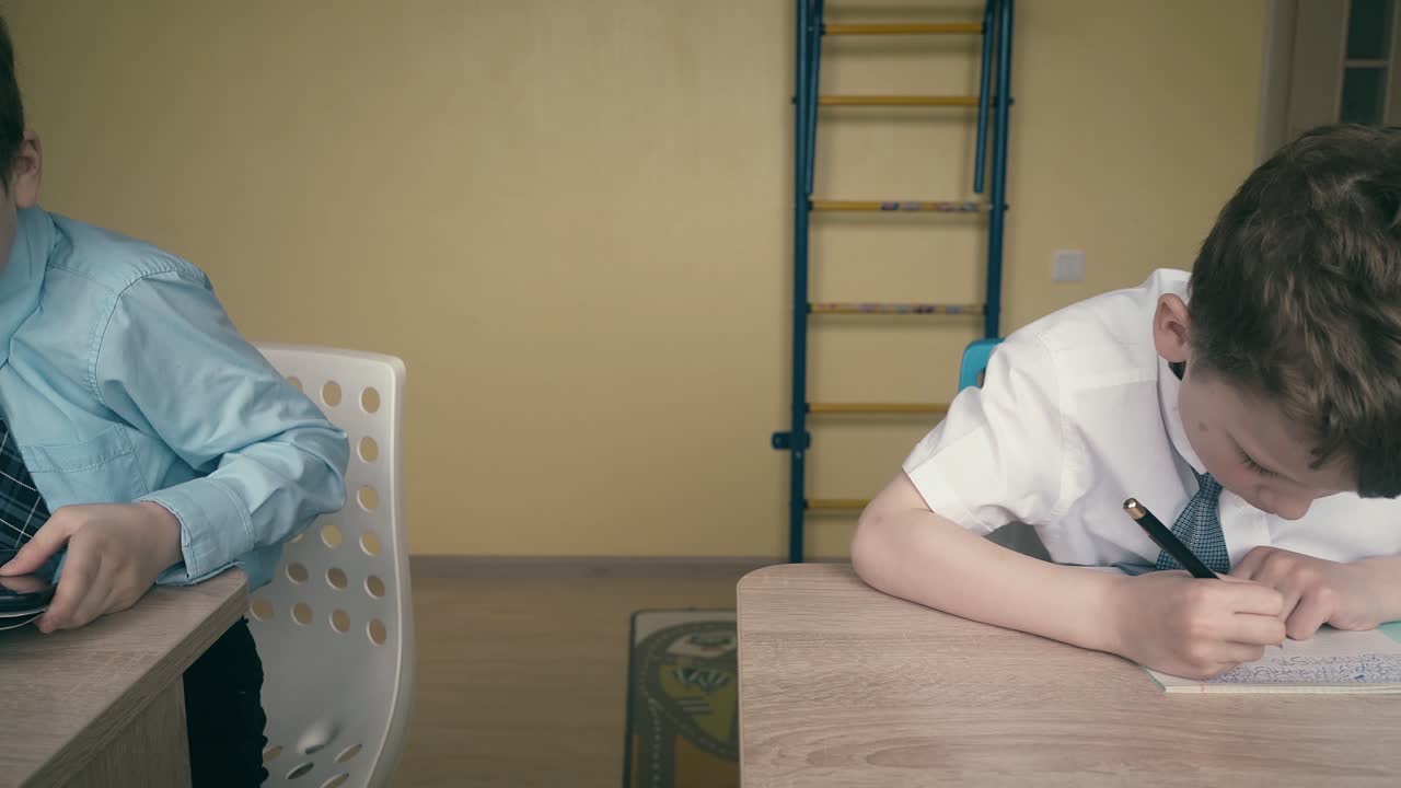 путешествующие ученики маленькие мальчики делают домашнее задание 3 один из них делает рисунок в тетради