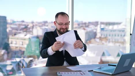 depressed businessman sitting at desk. bearded middle aged man in glasses feeling nervous at his workplace. portrait of sad businessman in office