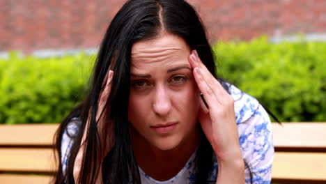 Sad-brunette-thinking-on-bench-in-the-park