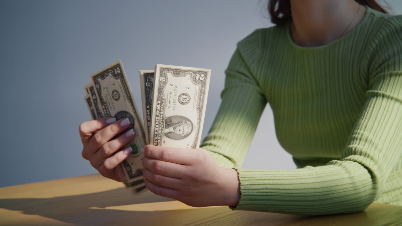 Woman hands checking amount of cash money at table closeup. Lady counting salary