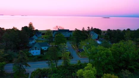 bright purple sunset over beach houses with colors reflecting off ocean waves and vacation homes along the new england atlantic coastline