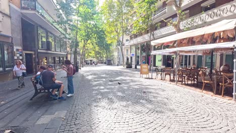 two people talking on a sunny street