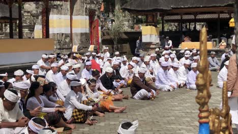 group of religious people taking part in a ceremony at ulun danu bratan temple in bali, indonesia