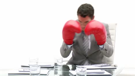 competitive business man holding boxing gloves
