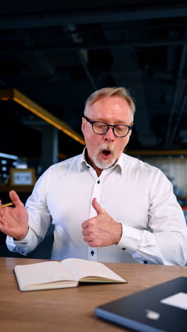 bearded man in white shirt having lots of work to do. man looks at his daybook and gestures that everything is ok. vertical video.