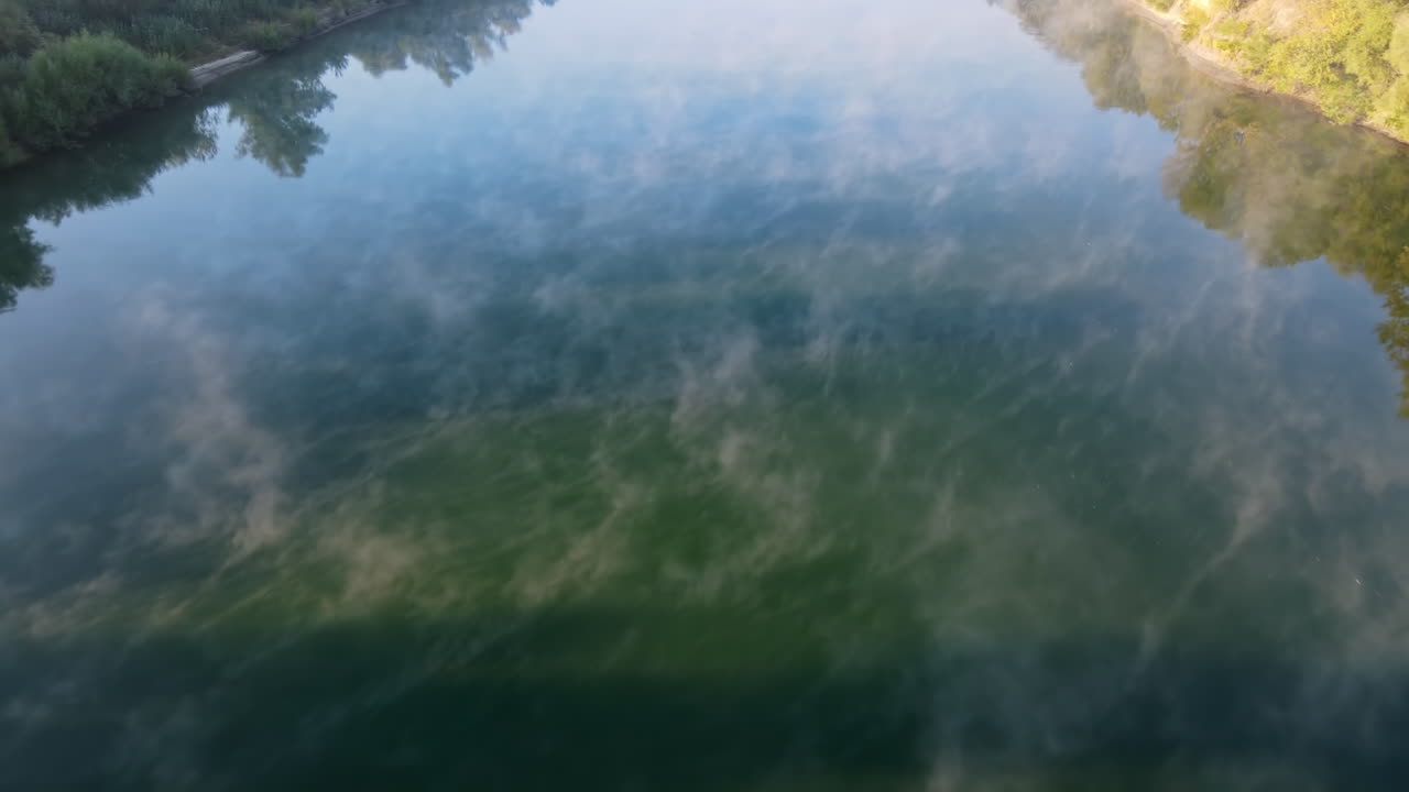 Luftfoto af naturen i Moldova ved solnedgang. Flod og frodig tåge over dens grønne områder
