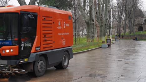 street sweeper cleaning the sidewalk in a park