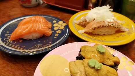 cierre los platos de sushi en el restaurante japonés, erizo de mar y sushi de salmón, japón
