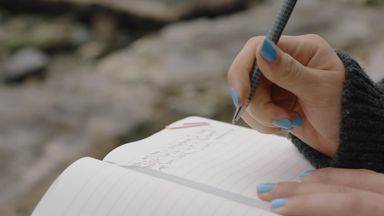 close up hands woman writing in diary journal teenage girl expressing lonely thoughts on seaside beach