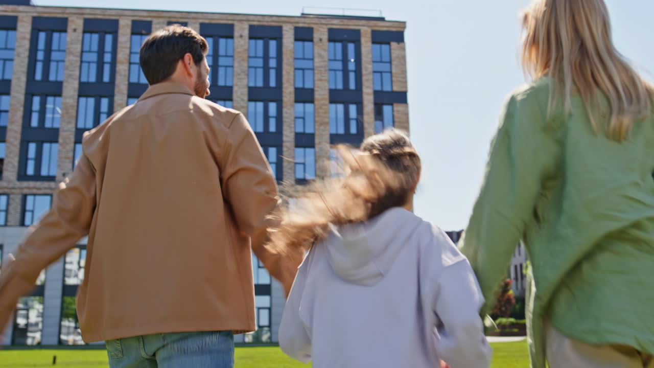 Friendly family walking together at residential complex. Parents kid strolling