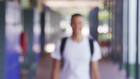 un adolescente de raza mixta se enfoca en el corredor de la escuela