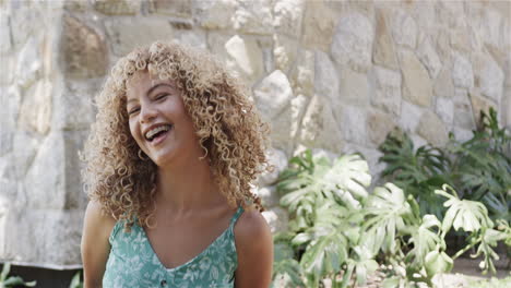 young biracial woman laughs joyfully outdoors, with copy space