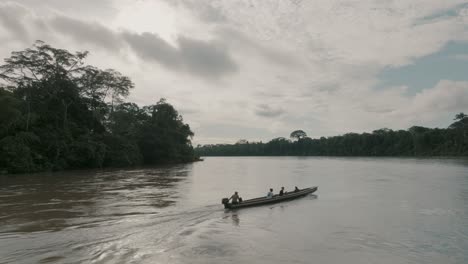 Aerial-shot-of-passenger-boat-travelling-on-the-Amazon-river-between-the-dense-forest