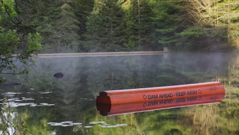 Steam-Rising-On-Lake-With-Spillway-Dam-Infrastructure,-Nature-Landscape