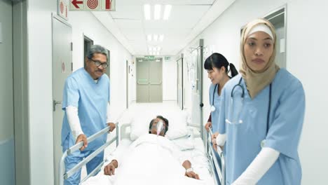 Trabajadores-De-La-Salud-Empujando-A-Un-Paciente-En-La-Cama-Por-Un-Pasillo-Del-Hospital-4k