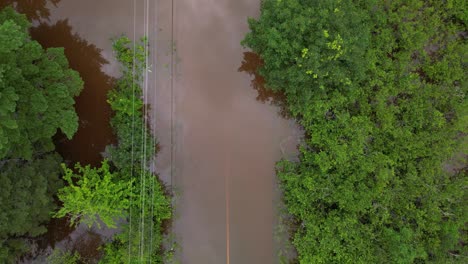 Top-down-flooded-road-submerged-underwater-due-to-river-overflowing-after-extreme-weather-event