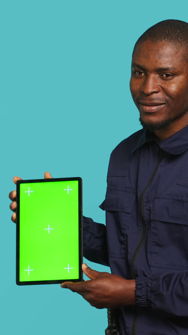 Uomo afroamericano che tiene in mano un tablet con green screen