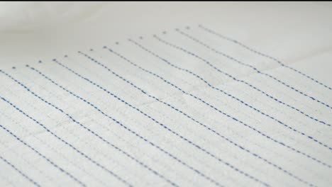 botones coloridos que caen en la tela a rayas de primer plano. confección de ropa y concepto de costura profesional. elección de accesorios de botones para el material