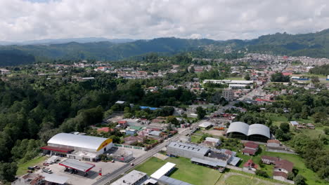 aerial video of chichicastenango shows green hills and a sprawling town with colorful rooftops and wide streets framed by forested valleys