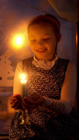 young girl with a joyful expression holding a lit candle in a cozy indoor setting, surrounded by festive decorations and warm ambient light