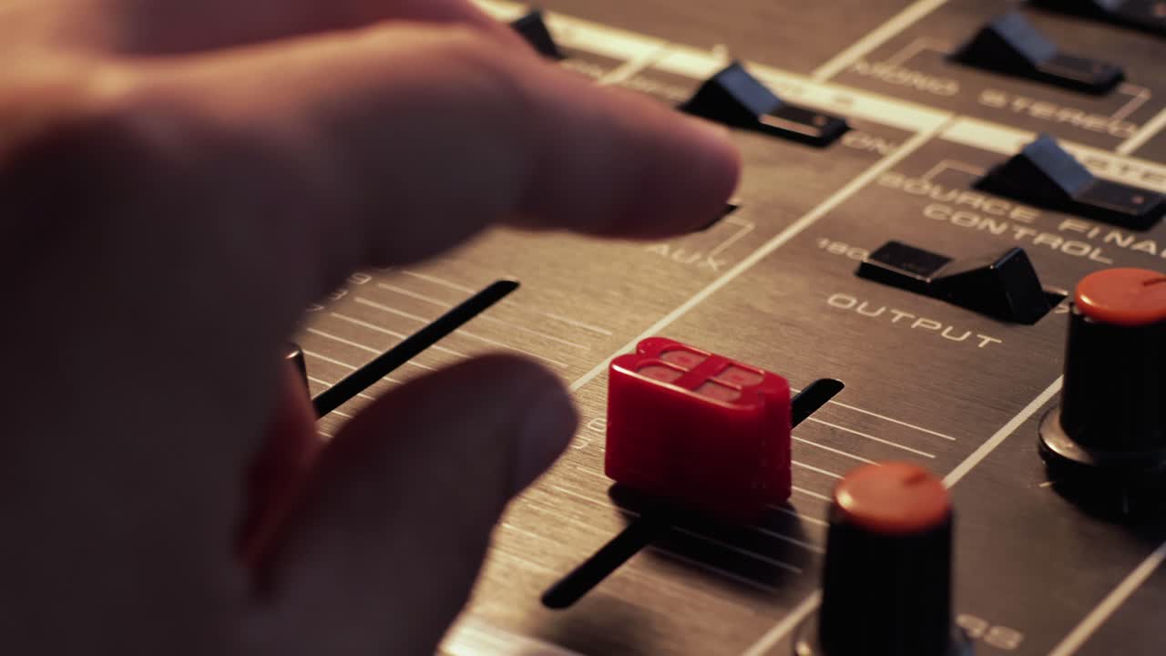 cerca de un dedo bajando el volumen en un mezclador estéreo