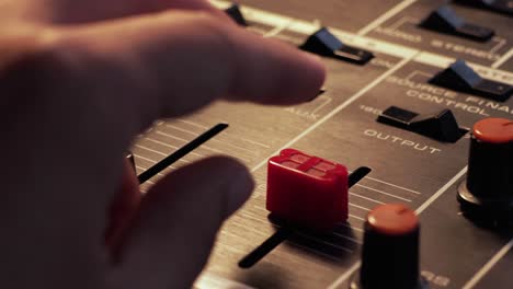 Close-up-of-a-finger-putting-down-the-volume-on-a-stereo-mixer