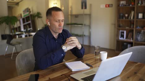 adult businessman in headphones discussing important things using video call