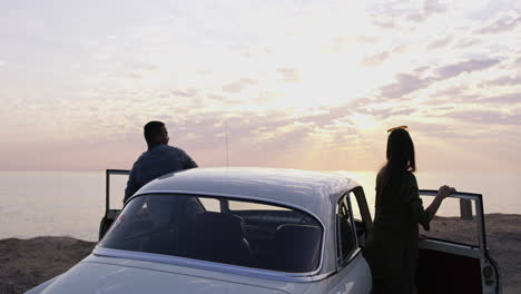 Puesta-De-Sol,-Un-Auto-Y-Una-Pareja-En-Un-Viaje-Por-Carretera