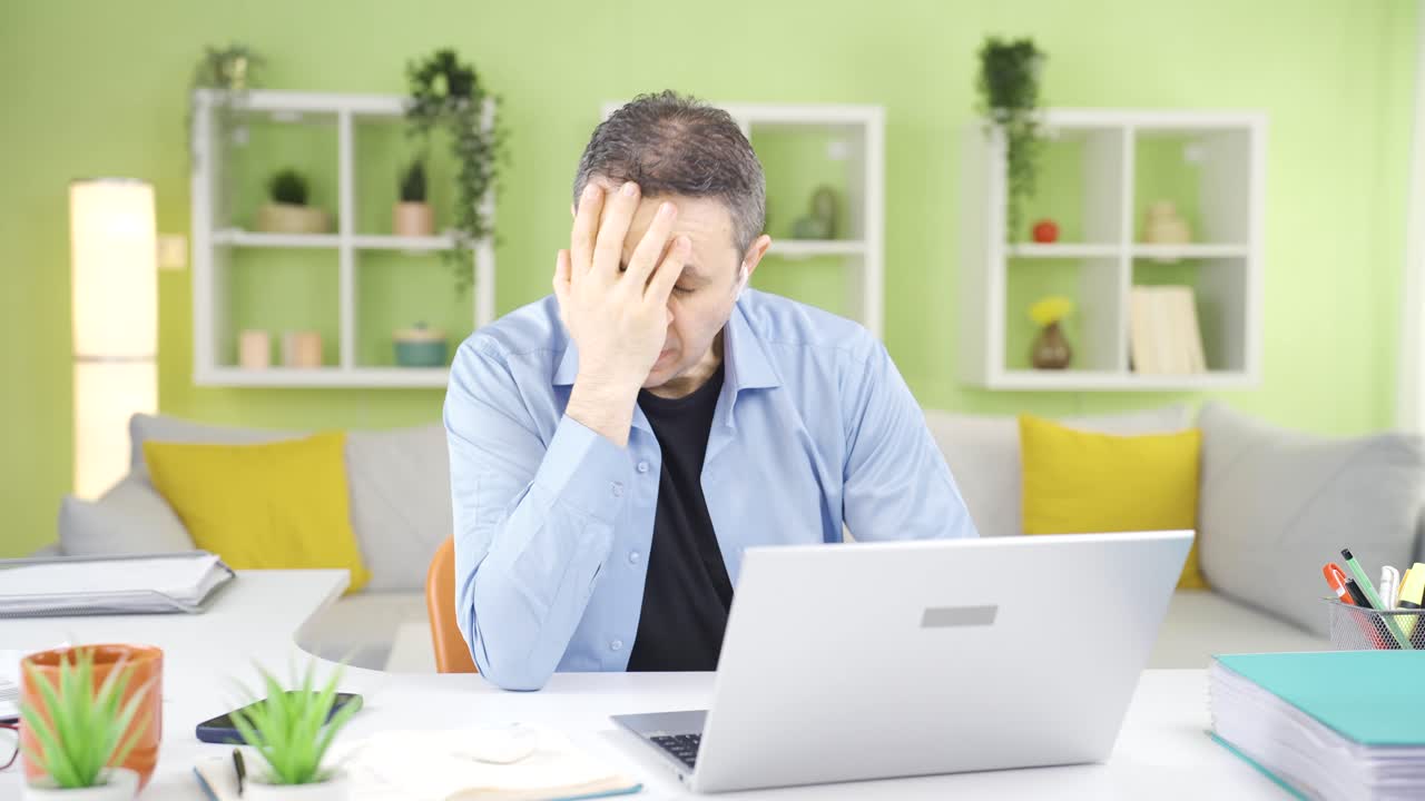 hombre soñoliento bostezando en la computadora.