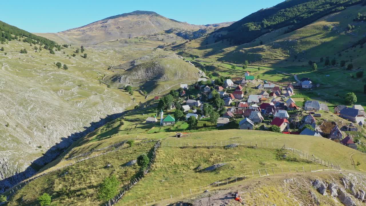 Charming mountain bucolic village on valley in Bosnia. Aerial forward
