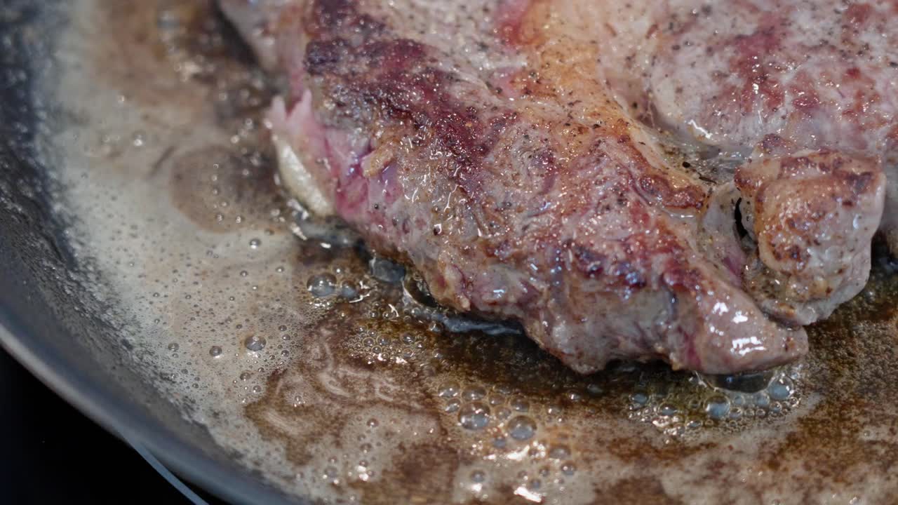 primer plano del borde de la carne frita en una sartén caliente, marrón en la parte superior con carne roja debajo, textura detallada visible 60 fps